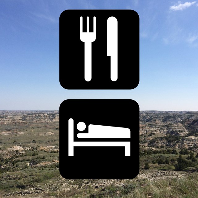 international symbols for lodging and dining in front of a badlands scenic backdrop