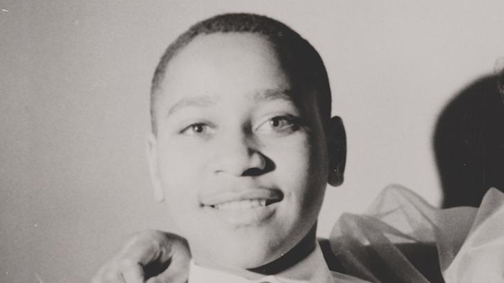 A black and white portrait of a young man smiling.