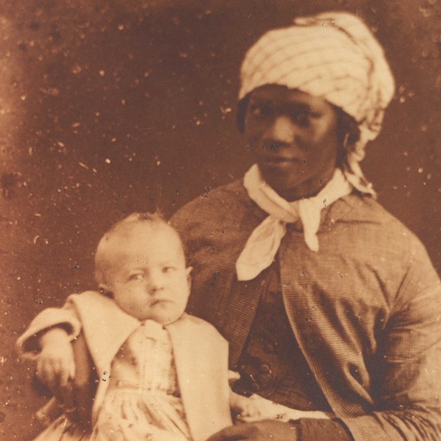 enslaved woman holding her owners child