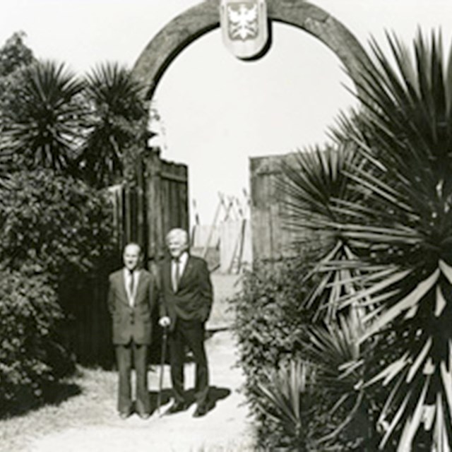 black and white image of two men at gate to Fort Caroline model 