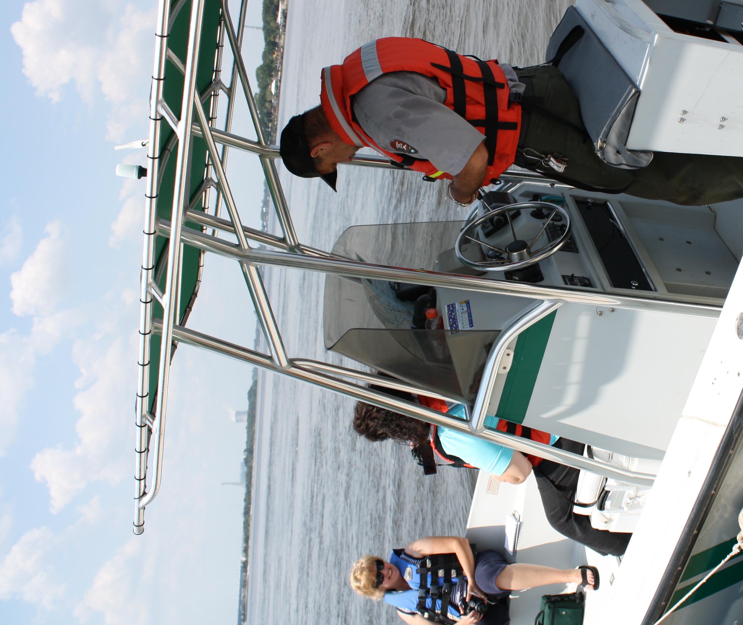 ranger in life vest at helm of boat