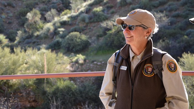 Person with a volunteer uniform on smiles.