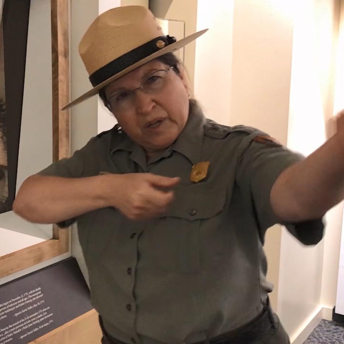 Anita holds her arms as if pointing a rifle.