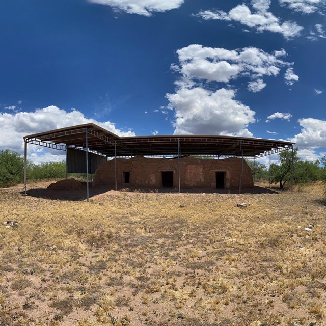 adobe structure with metal shed roof above