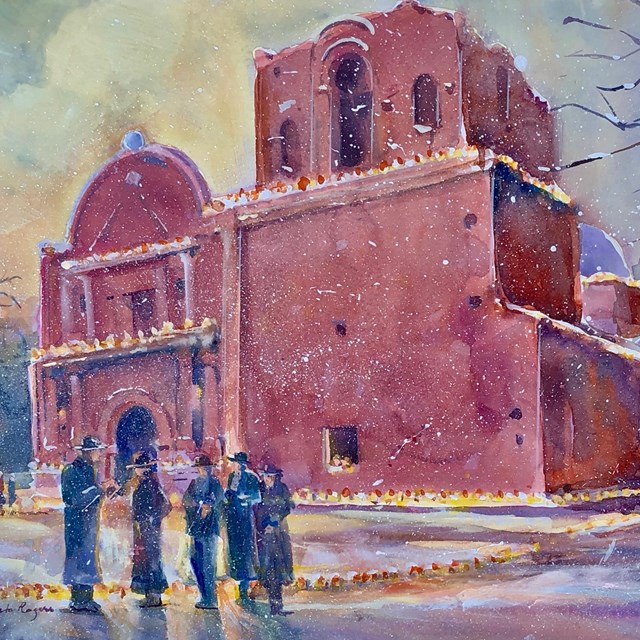 snow falling on mission with luminarias and figures