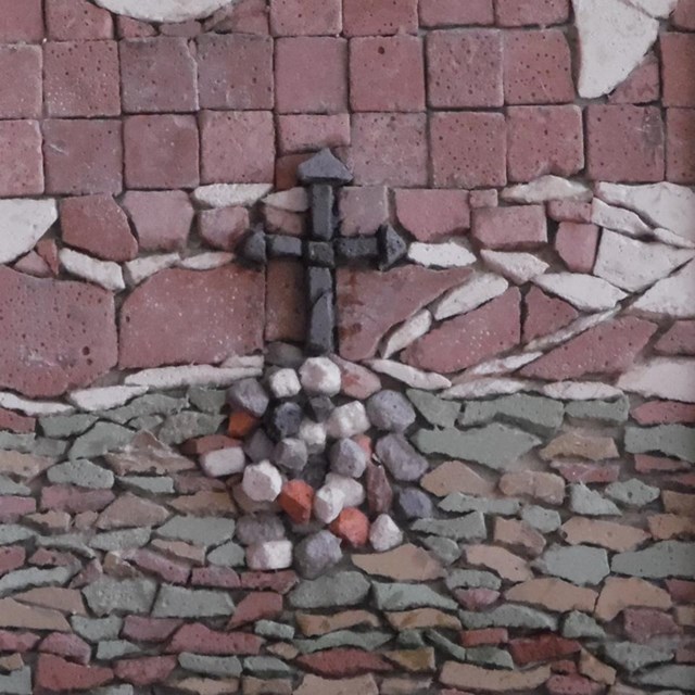A framed mosaic of church altar and cross.