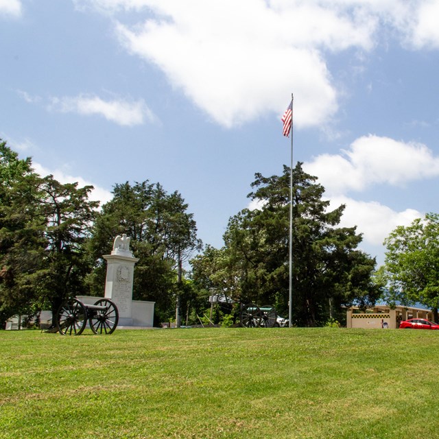 Two canons in front of a stone monument.