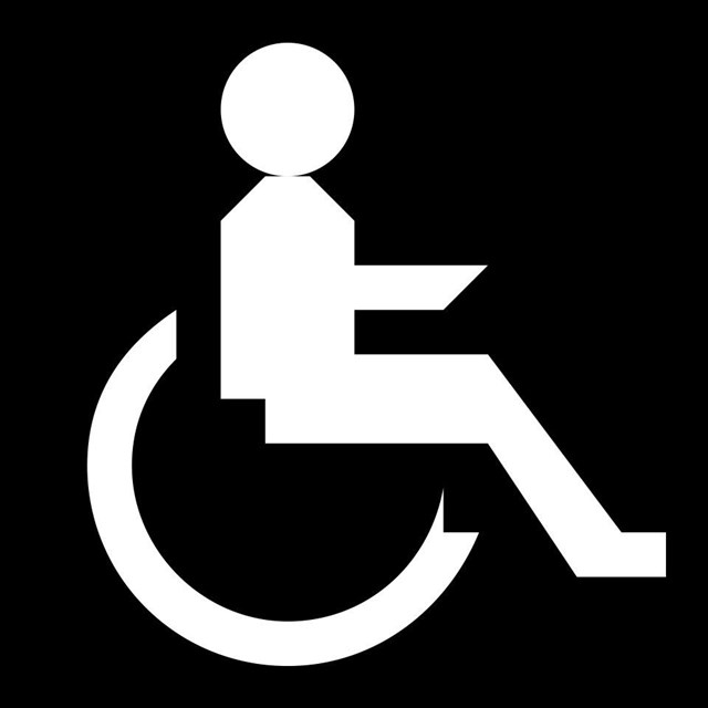 A black and white icon of a person in a wheelchair.