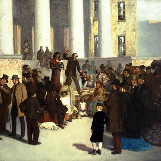 A crowd gathered around a courthouse watch as enslaved African Americans are auctioned. 