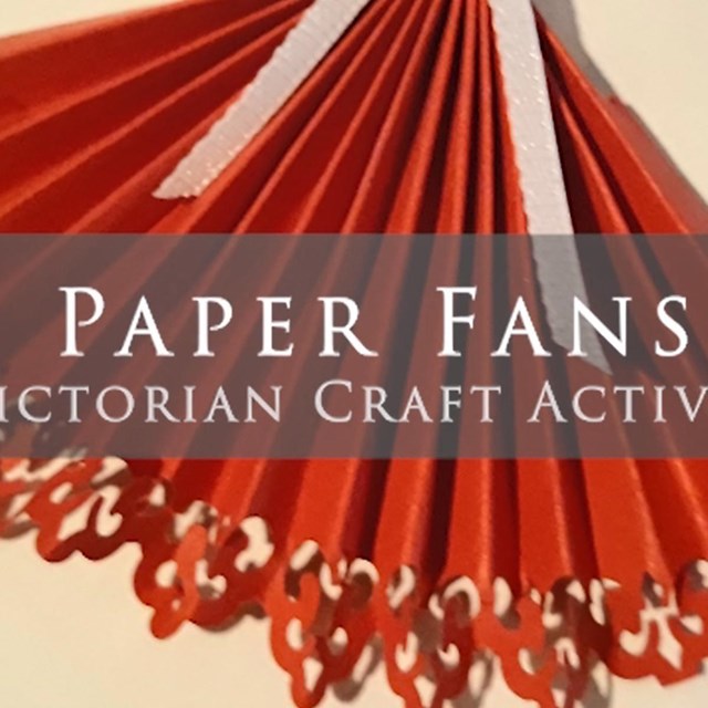 Red folded paper fan with decorative scalloped edge and a white ribbon. Text reads 'Paper Fans'