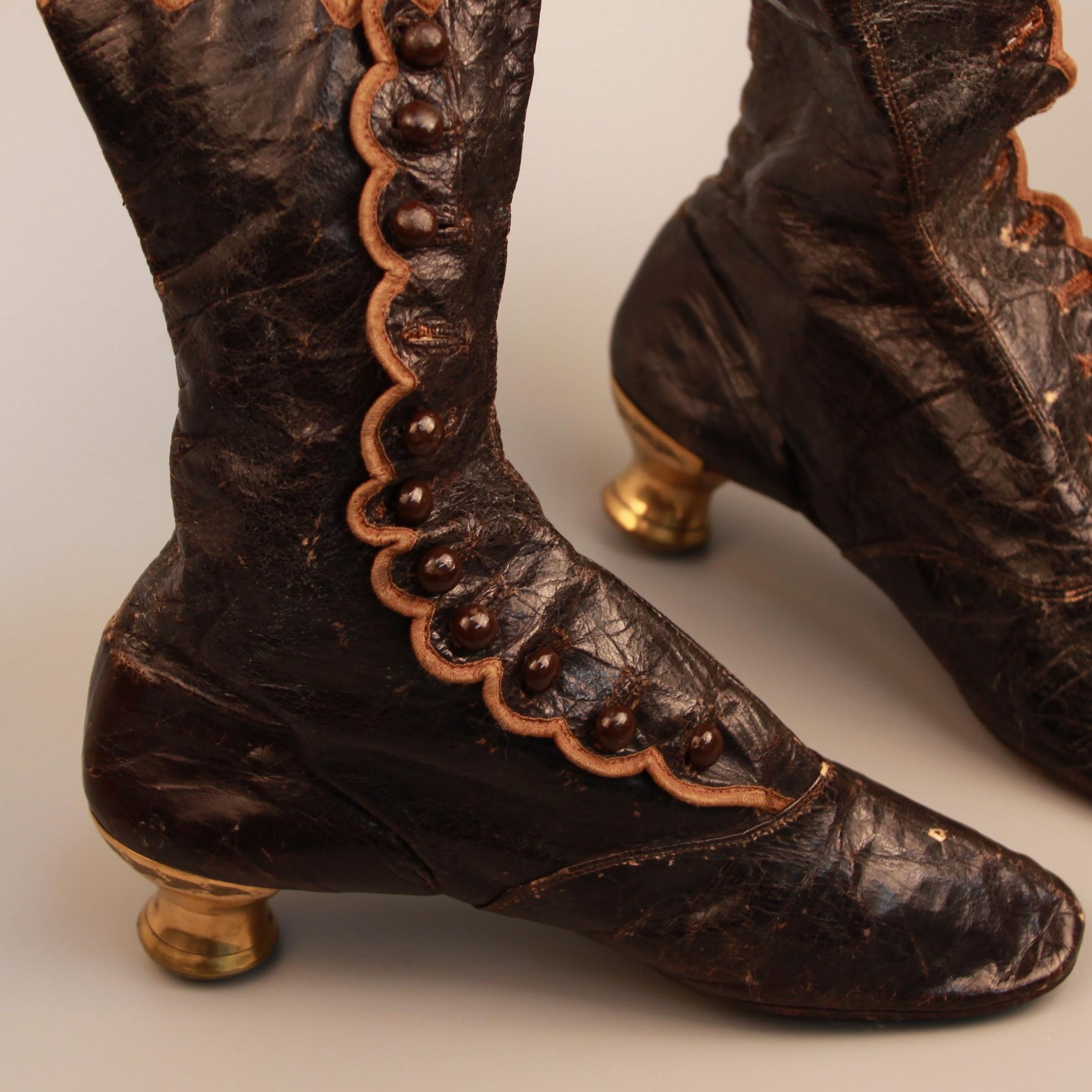 Pair of brown leather boots with gold heels