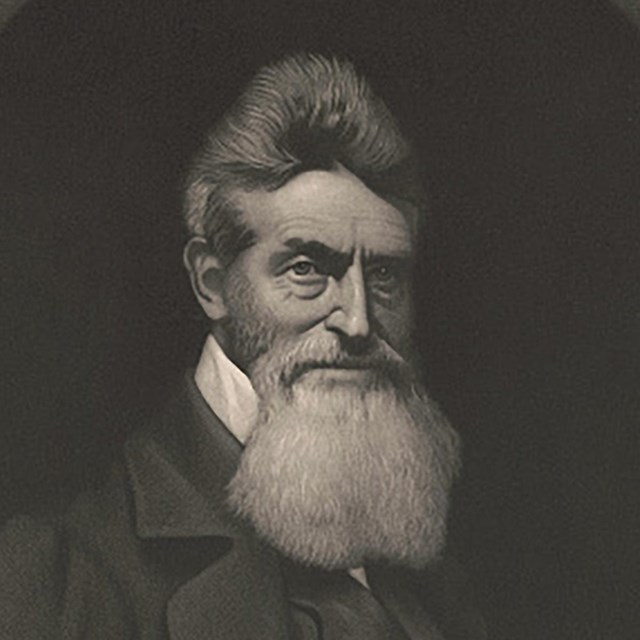 A portrait of abolitionist John Brown with short hair and a long, gray beard.