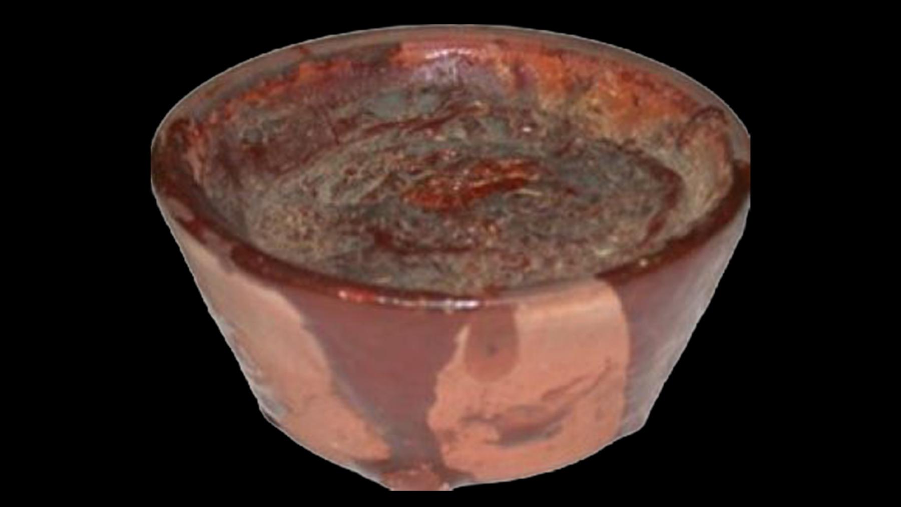 photograph of redware bowl on black background.