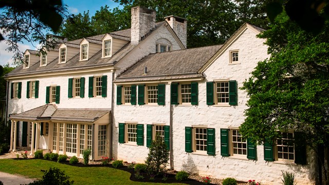 White Queen Ann style mansion with green shutters