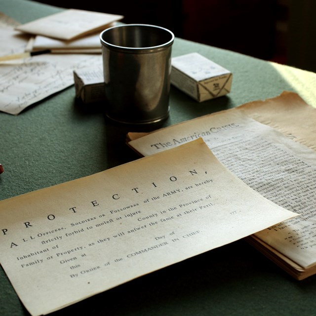 a close up of replica historic documents on a green table cloth.