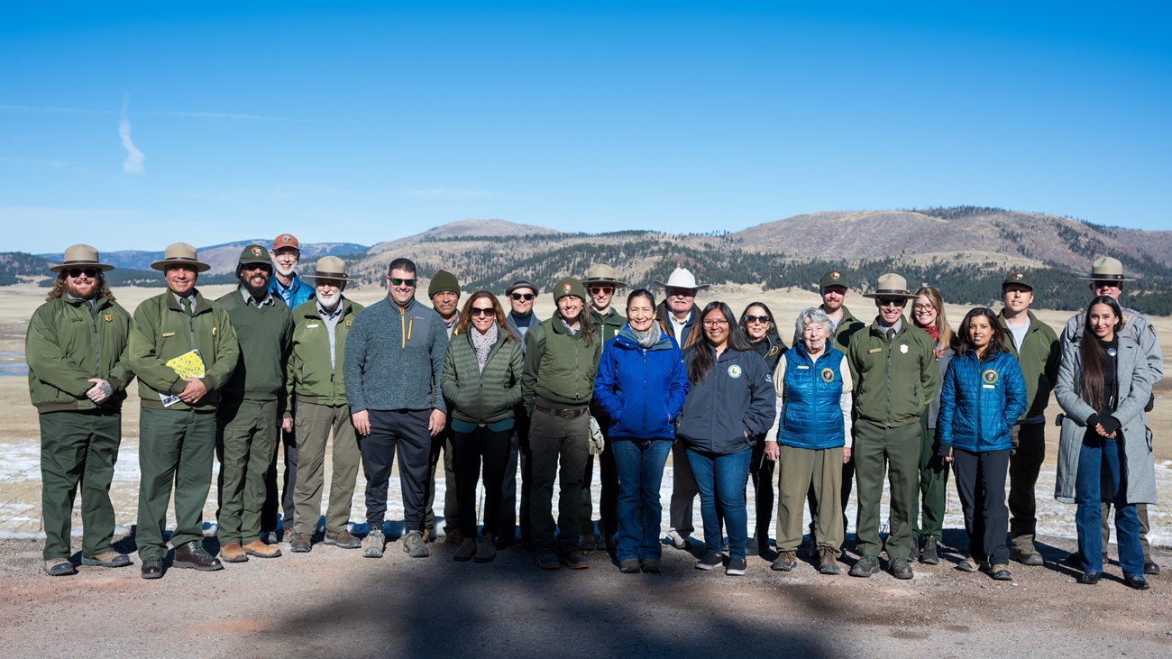 A group of park rangers and tribal leaders standing together at an overlook.