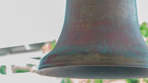 A brown, tarnished bell close-up photo