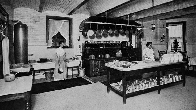 Two women in a large kitchen.