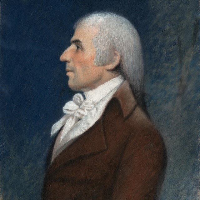 A pastel portrait of a man in profile wearing a powdered wig and brown coat.