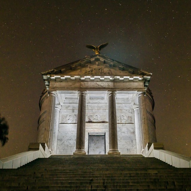 The Illinois Monument illuminated from the inside at night. 