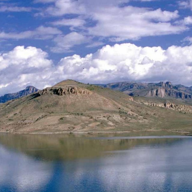 Photo of an island in a lake under a cloudy sky.