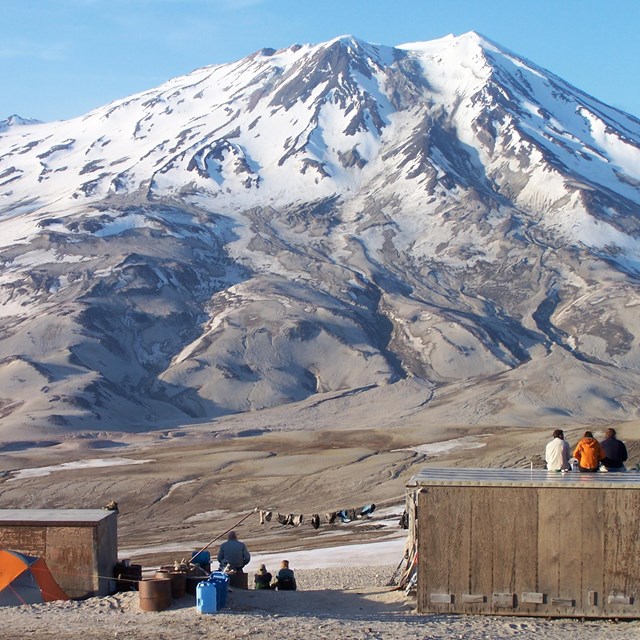volcanic mountain with cabins in foreground