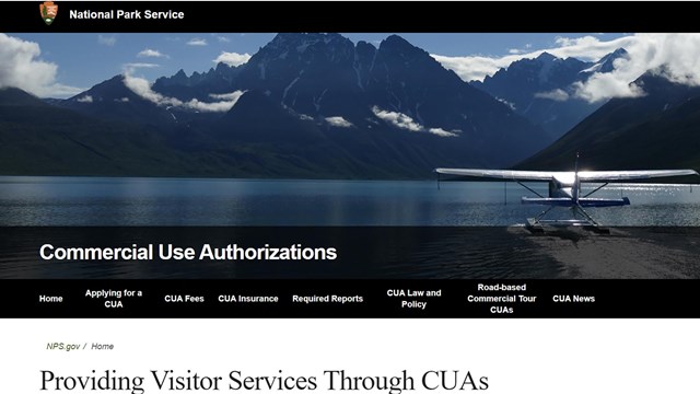 Screenshot of a float plane on the surface of a scenic lake, pointed towards mountains on the shore.