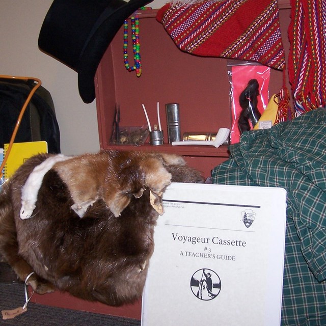 A Variety of voyageur costume props sitting on a trunk