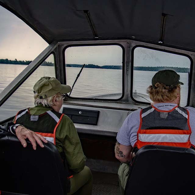 Image of 4 adults with PFDs in a boat on the water