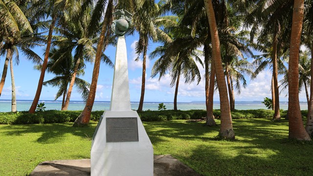 A white obelisk. On the top of it is a ball with an eagle perched on top.