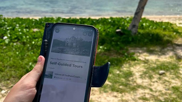 A phone open to the self-guided tour page for War in the Pacific National Historical Park. 