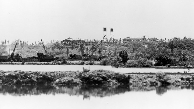 Ruins of several buildings and two large fuel tanks
