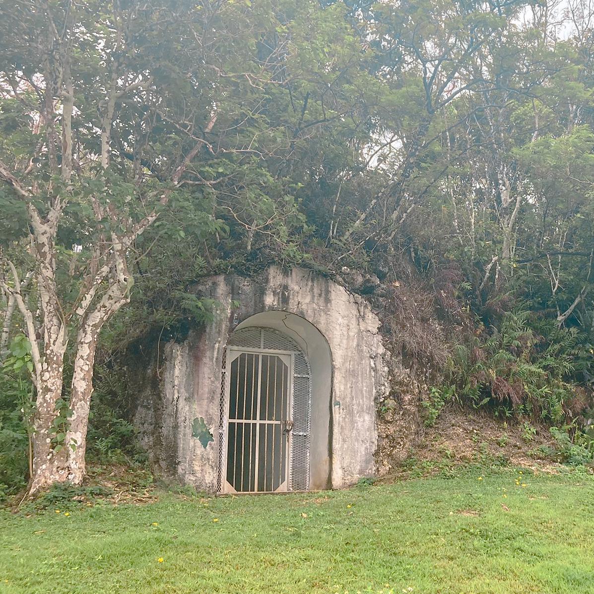 A gated concrete archway build into a hill.