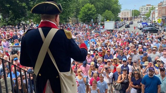 Man dressed in revolutionary attire adddressing crowd