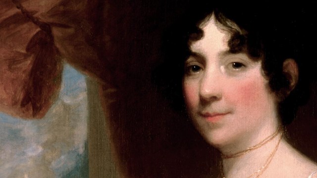 Portrait of First Lady Dolley Madison as a young woman in her 30s, surrounded by plush red velvet 