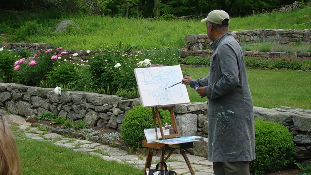 Impressionist Artist Dimitri Wright paints in a garden.