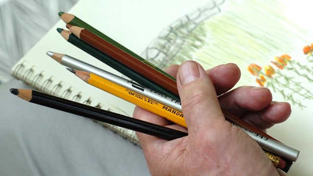 Artist holdin pencils drawing the surroundings 