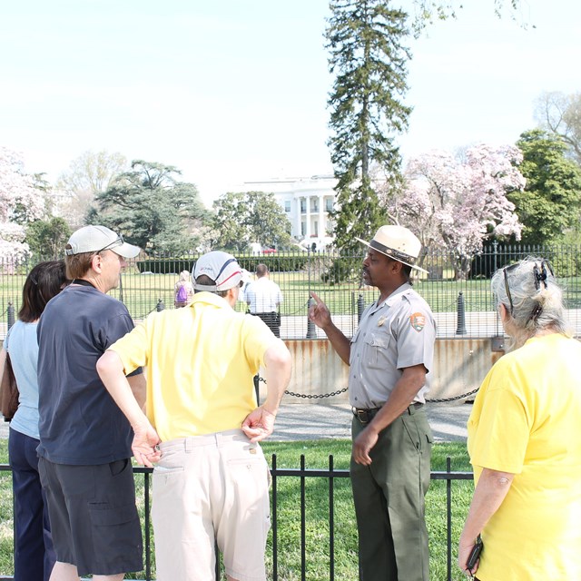 Ranger talking to visitors standing in front of the white house