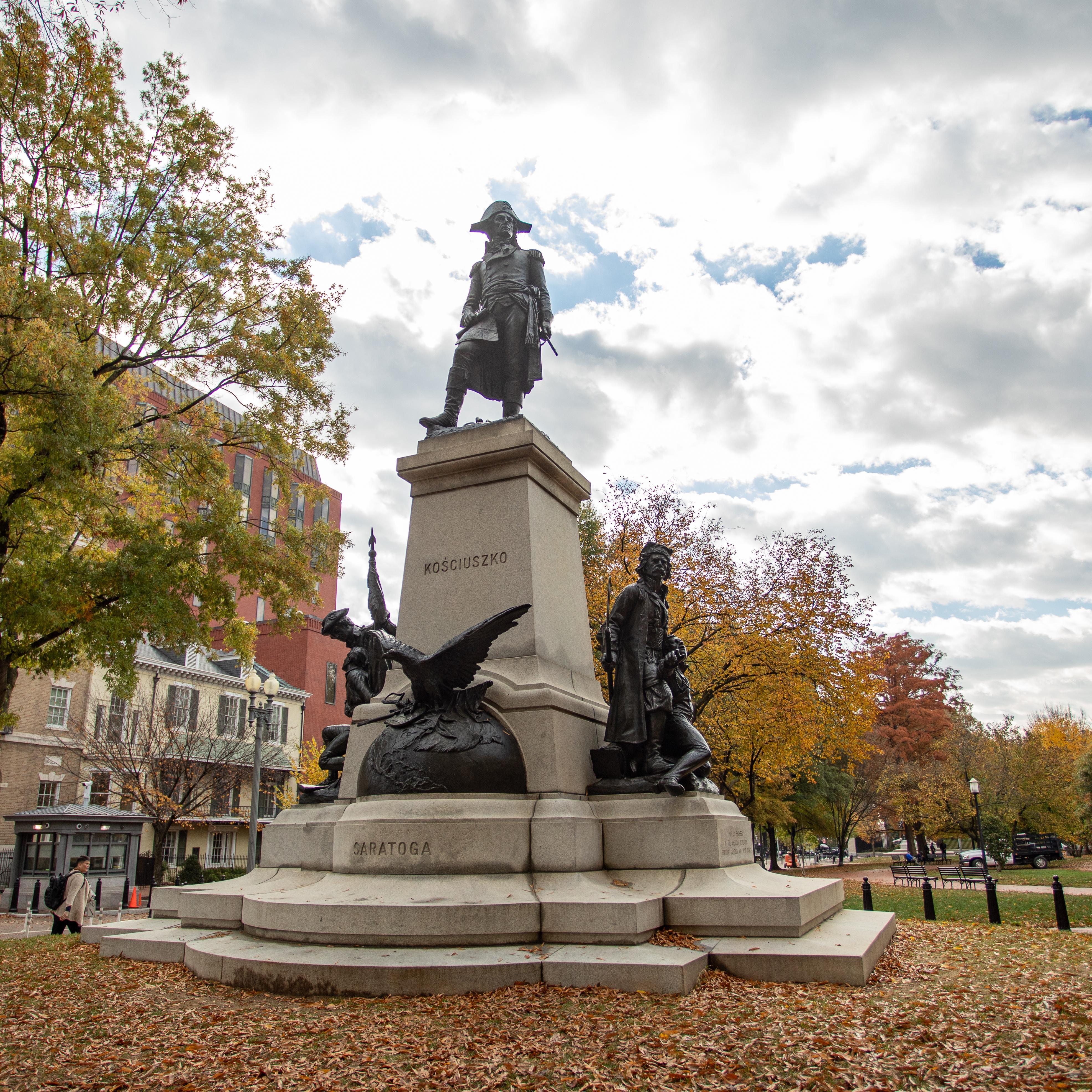 A bronze sculpture of Thaddeus Kosciuszko atop a stone plinth with an eagle and soldiers.
