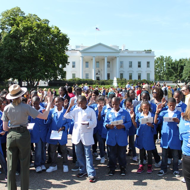 Ranger facing the White House with school children
