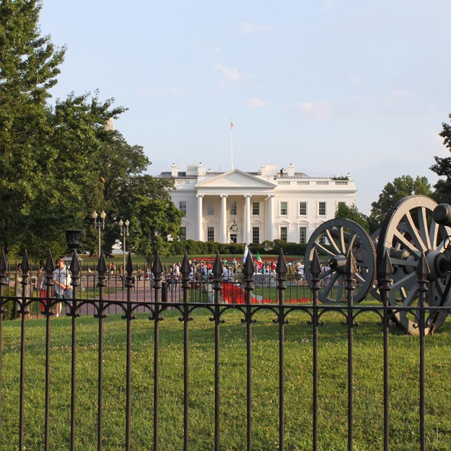 View of the White House from the center of Lafayette Park; with fence and cannons in foreground