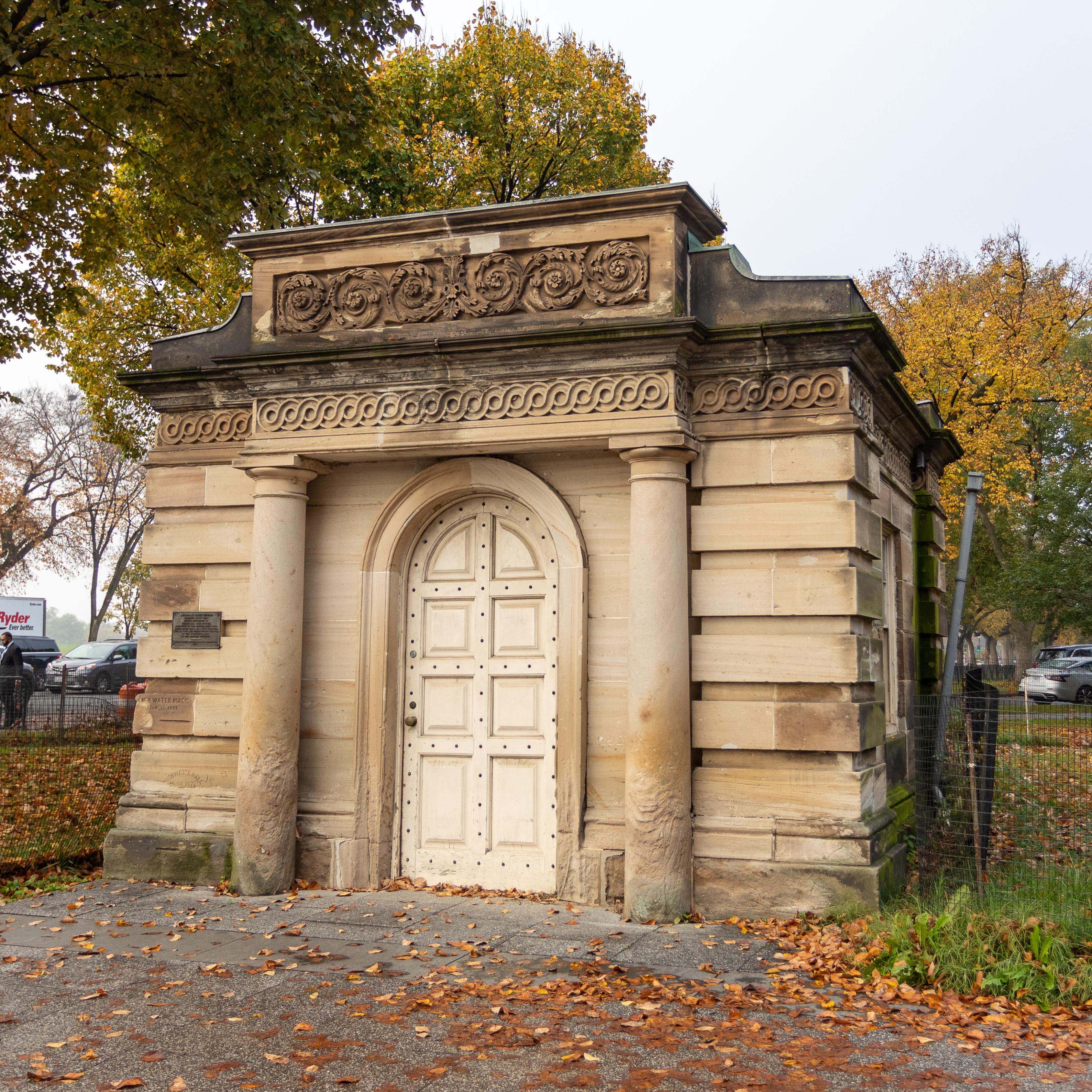 A cube-shaped stone building with an impressive door.