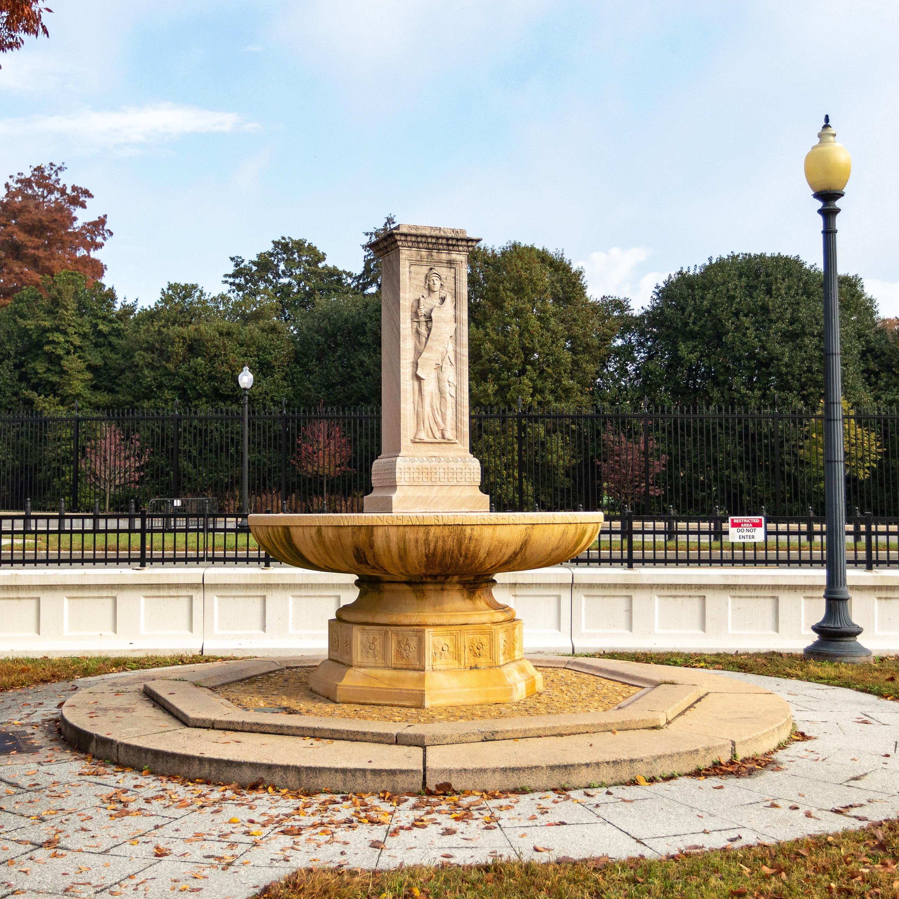 A rectangular stone sculpture rises from a saucer-shaped base.