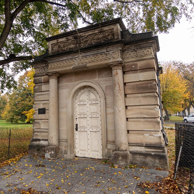 A stone, cube-shaped building with an impressive door.