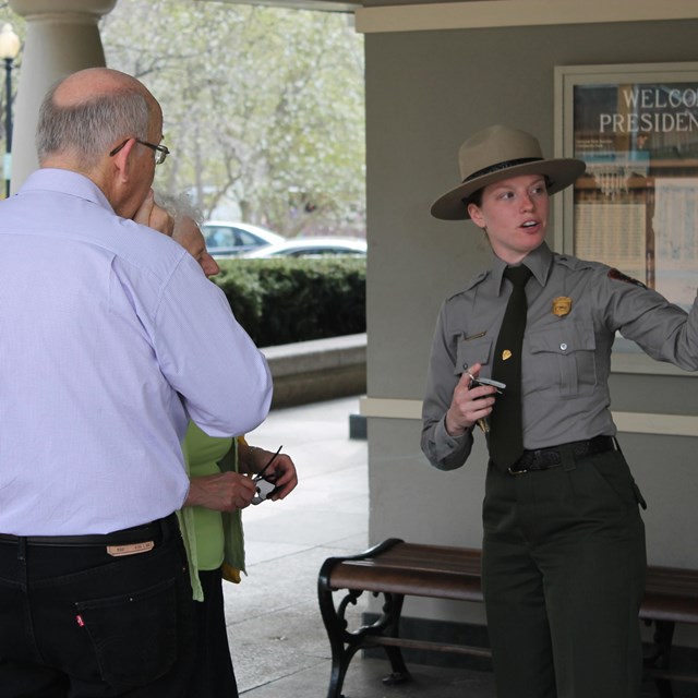 Ranger stands talking to visitors, giving directions