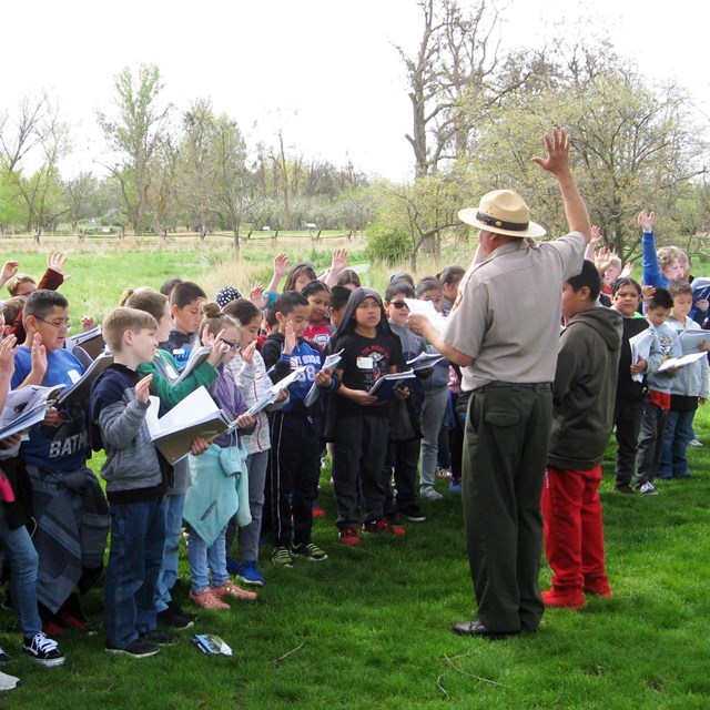 Large group of kids being sworn in by a ranger