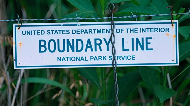 Sign on a fence reads United State Department of the Interior Boundary Line" 