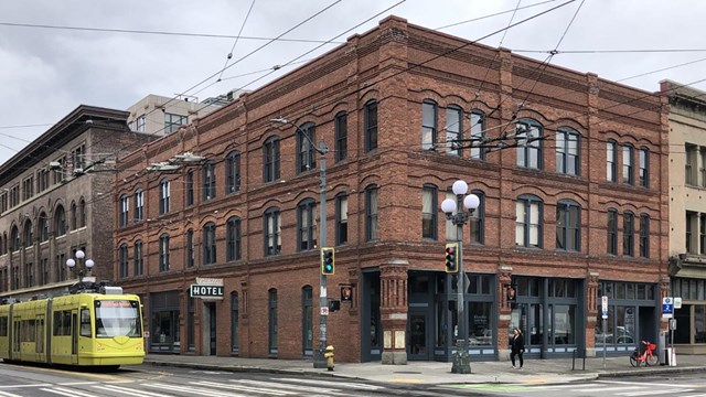 Brick building with glass windows on street corner.