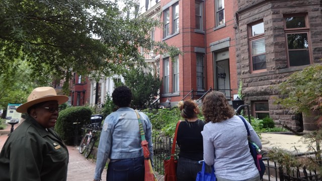Park ranger talking with group outside Mary McLeod Bethune House in DC. 