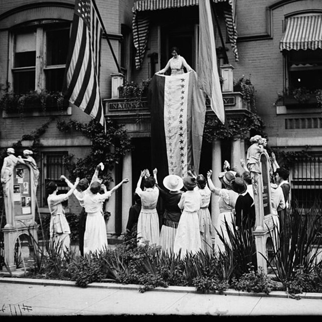 Women celebrate the 19th Amendment cheering in the street outside headquarters